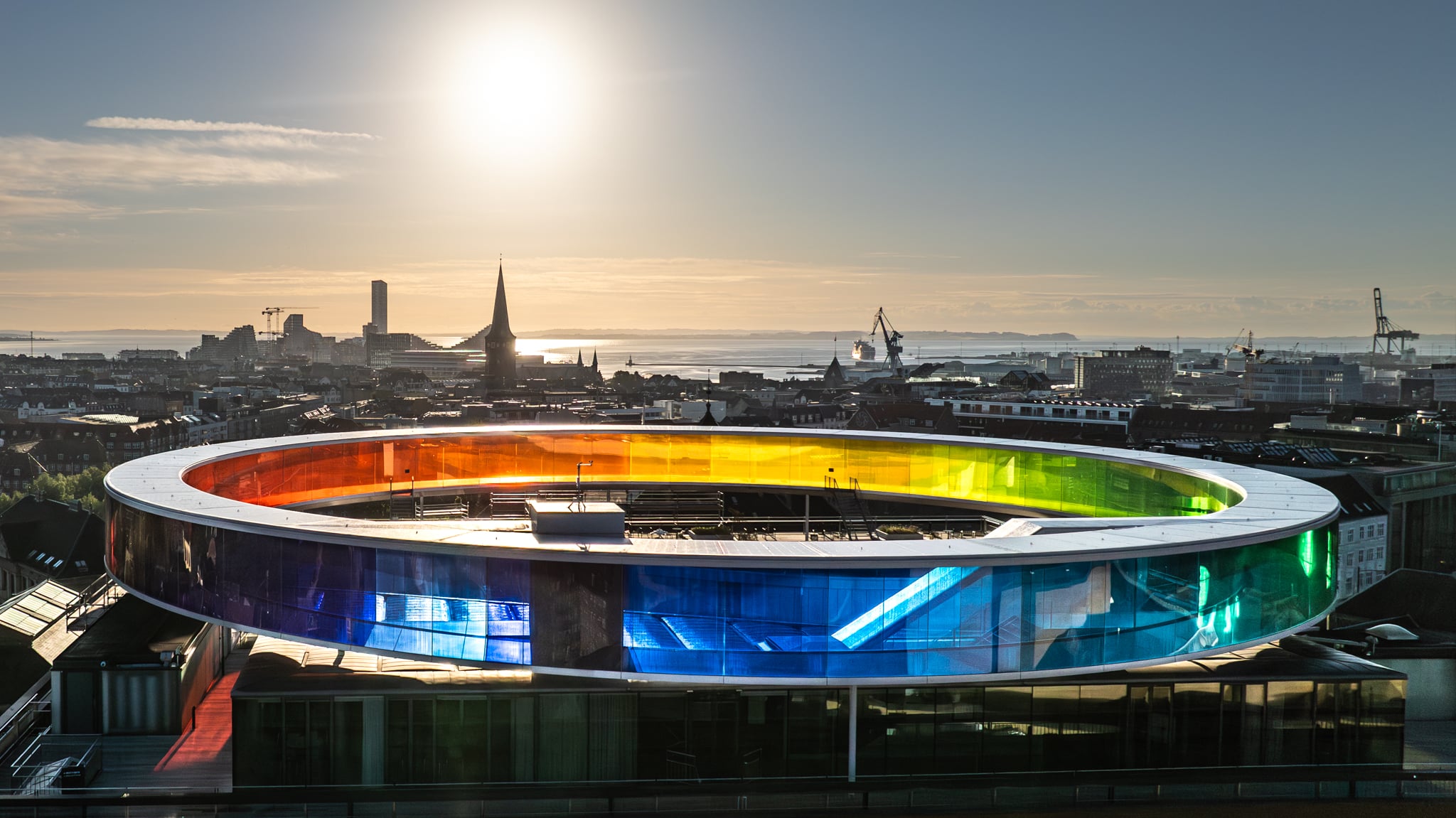 I forbindelse med åbningen af ARoS, James Turrell's, Skyspace - Domen "As Seen Below", stod jeg for drone entreprisen. Her stod jeg kl. 6 om morgenen for at lave de smukke billeder over ARoS og Aarhus. Your Rainbow Panorama af Olafur Eliasson står så smuk i forgrunden.